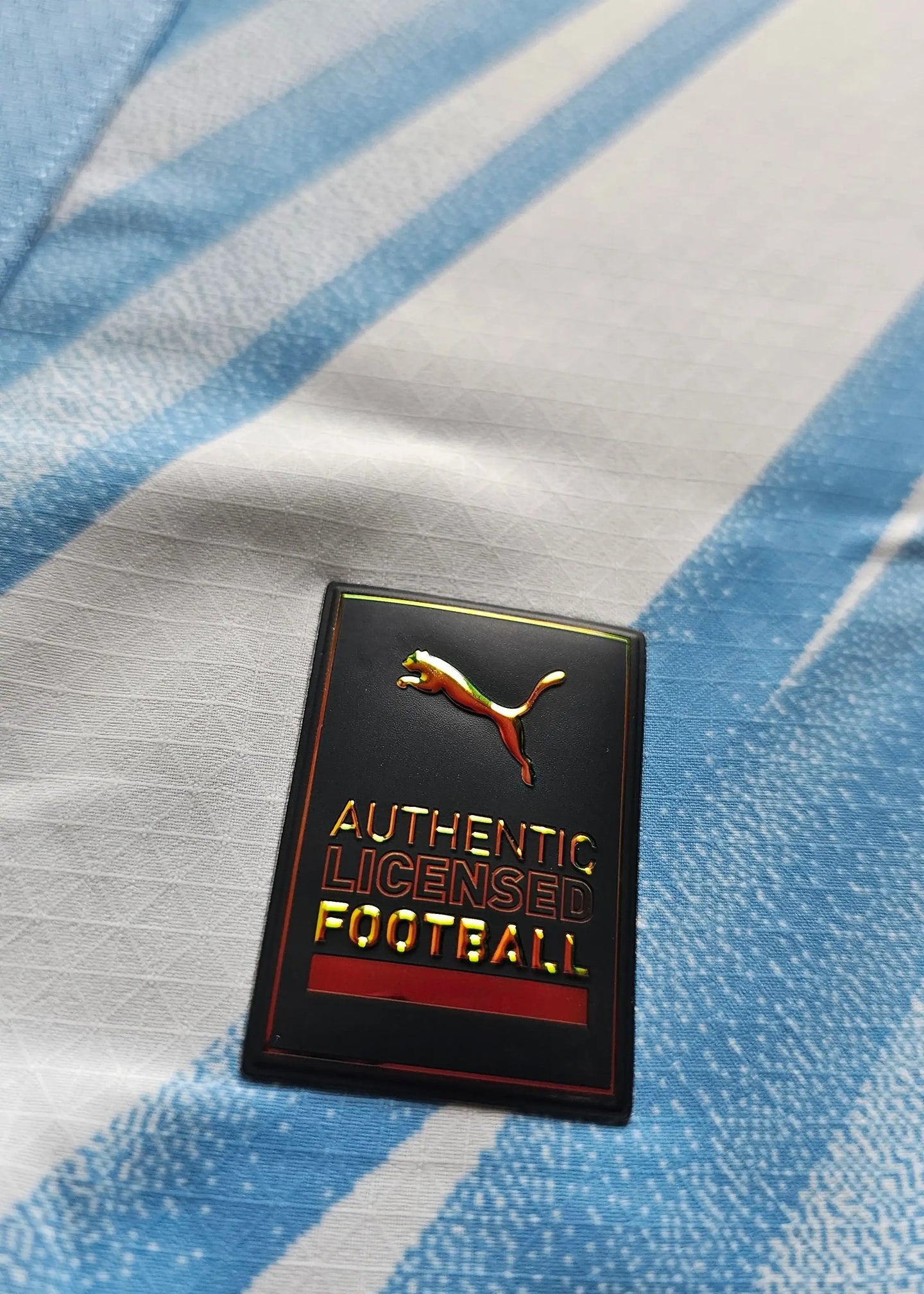 Crest detail showcasing the Puma logo alongside the text 'AUTHENTIC LICENSED FOOTBALL.'