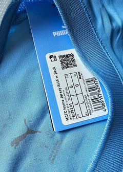Light blue detail of Manchester City shirt showing Puma logo and size label L.