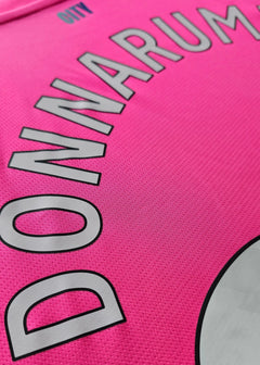 Close-up showing the name DONNARUMMA and CITY on a pink football shirt.