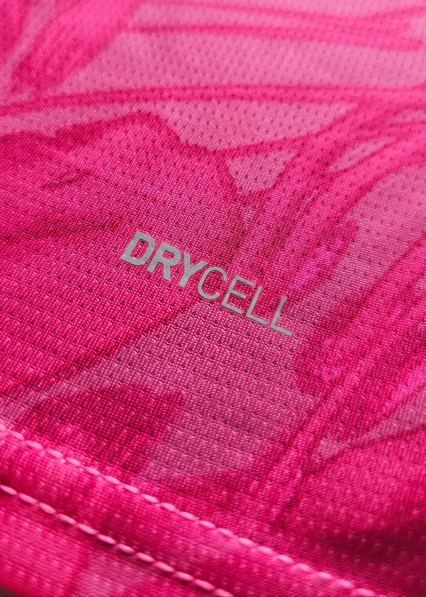 Close-up of the pink fabric featuring the word 'DRYCELL' on the signed football shirt.
