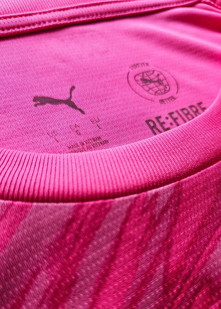 Close-up of pink fabric featuring Puma logo and RE:FIBRE branding details.