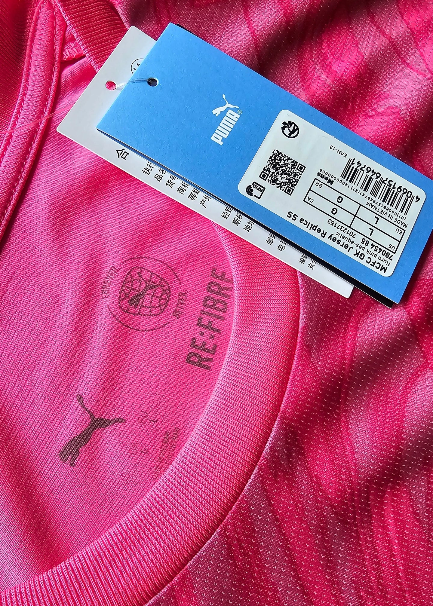 Detail view featuring pink fabric, Puma logo, and RE:FIBRE text on the collar area.