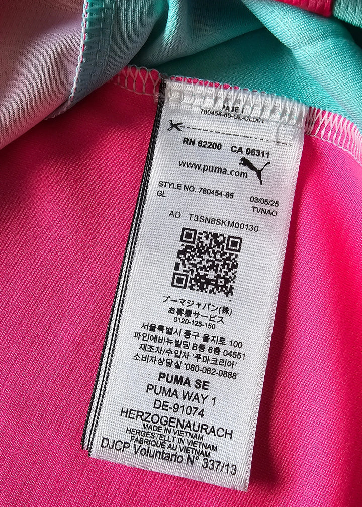 Detail view of tag showing PUMA SE, style number 780454-85, and pink fabric color.