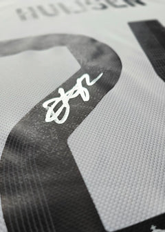 Close-up of No. 24 with the signature of Huijsen on a white football shirt.
