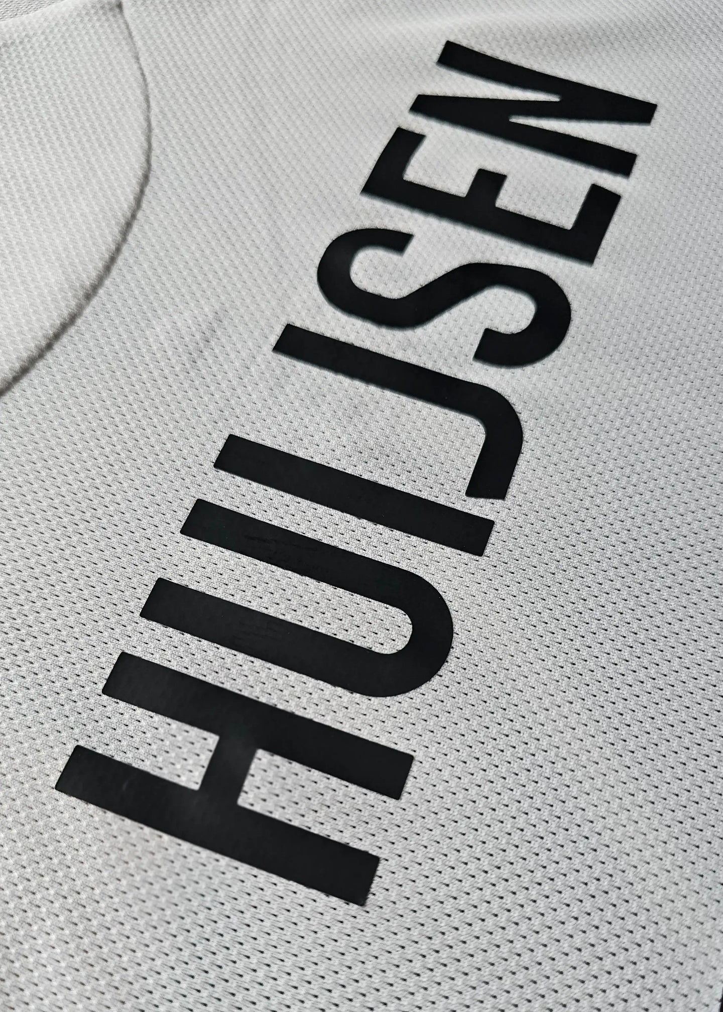 Close-up showing the name Huijsen in black on a white football shirt.