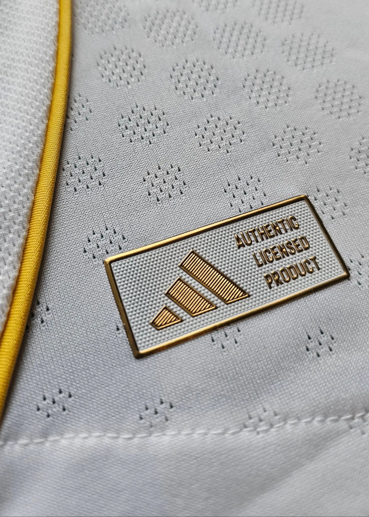 Close-up of the adidas badge stating AUTHENTIC LICENSED PRODUCT on a white shirt.