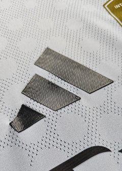 Close-up detail showing the textured fabric and black stitching on the signed football shirt.