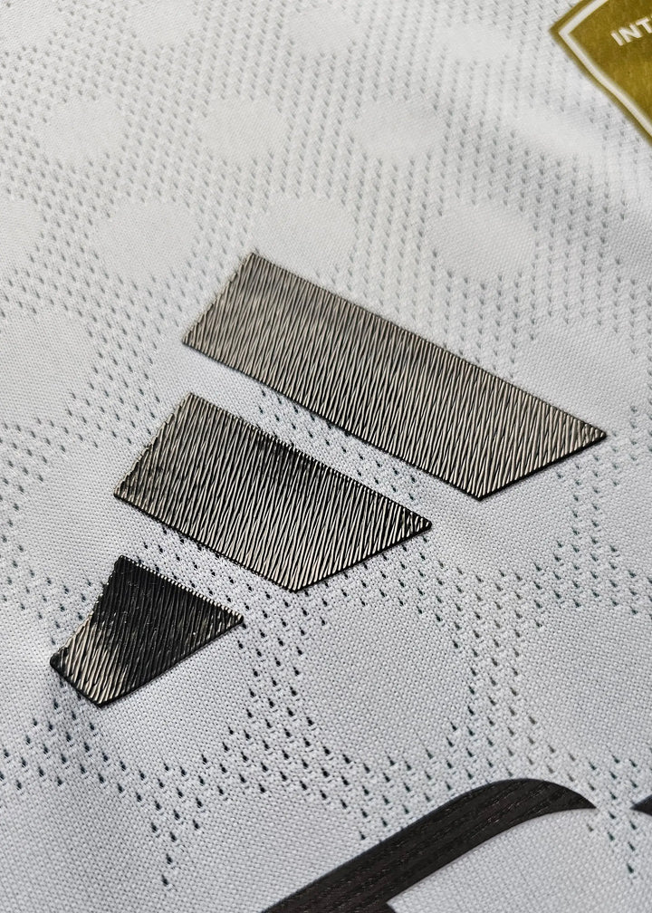 Close-up detail showing the textured fabric and black stitching on the signed football shirt.
