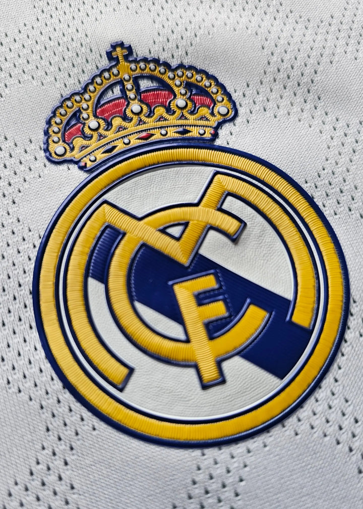 Crest detail featuring the Real Madrid CF logo with a crown, prominent in gold and blue.