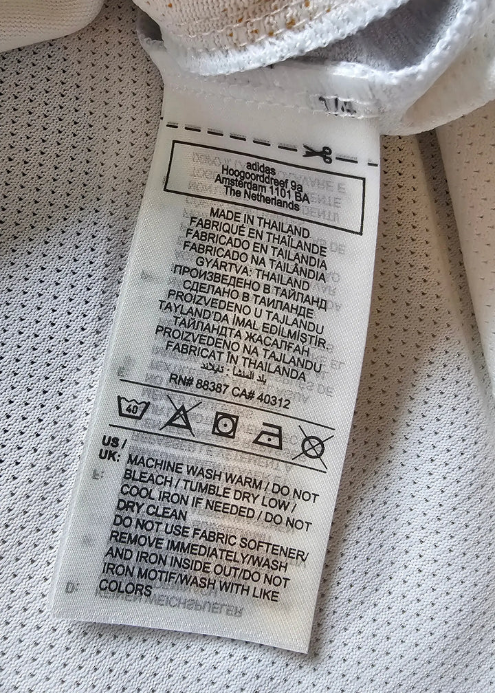 Label showing care instructions and manufacturer details for the football shirt.