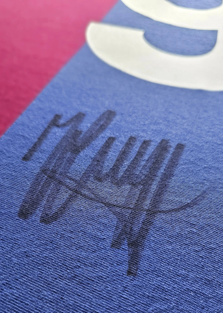 Close-up showing the signature of Johan Cruyff on a blue section of the football shirt.