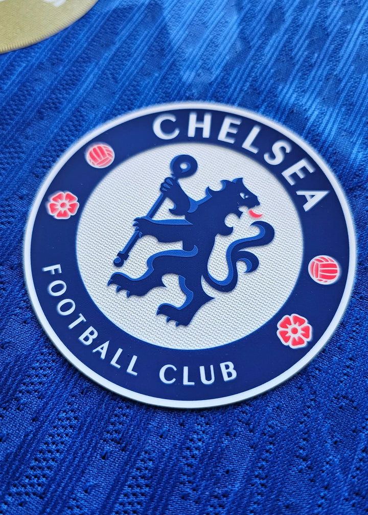 Close-up of the Chelsea F.C. crest featuring a lion, with text reading CHELSEA FOOTBALL CLUB.