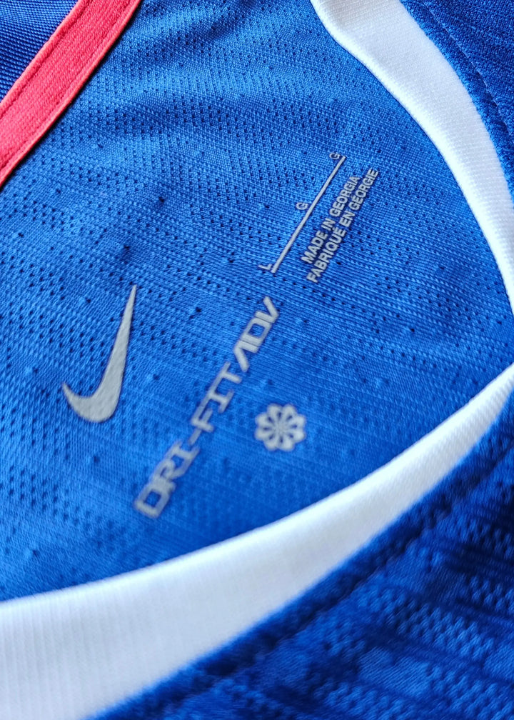 Close-up of label featuring Nike logo, ORI-FIT ADV text, and care instructions on blue shirt.