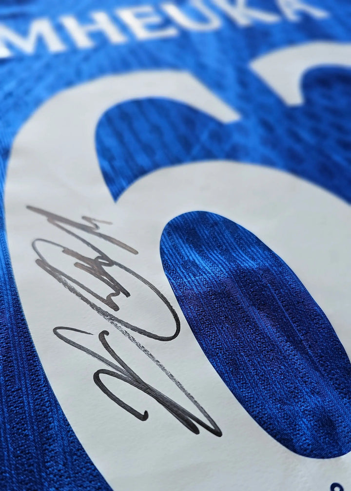Close-up of the number 62 on a blue football shirt with a visible signature.
