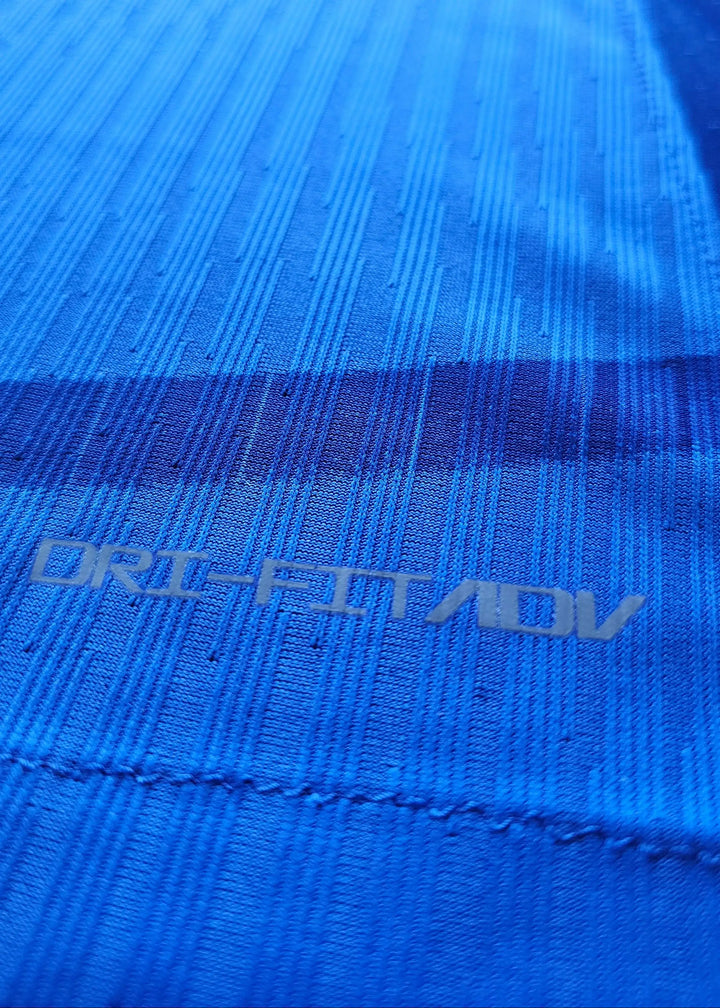Close-up showing the blue fabric texture and DRI-FIT ADV label detail.