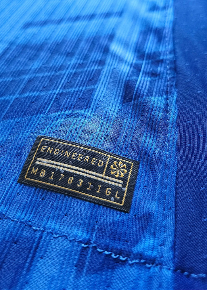 Close-up showing the 'ENGINEERED' tag and 'MB178311GL' on a blue football shirt.