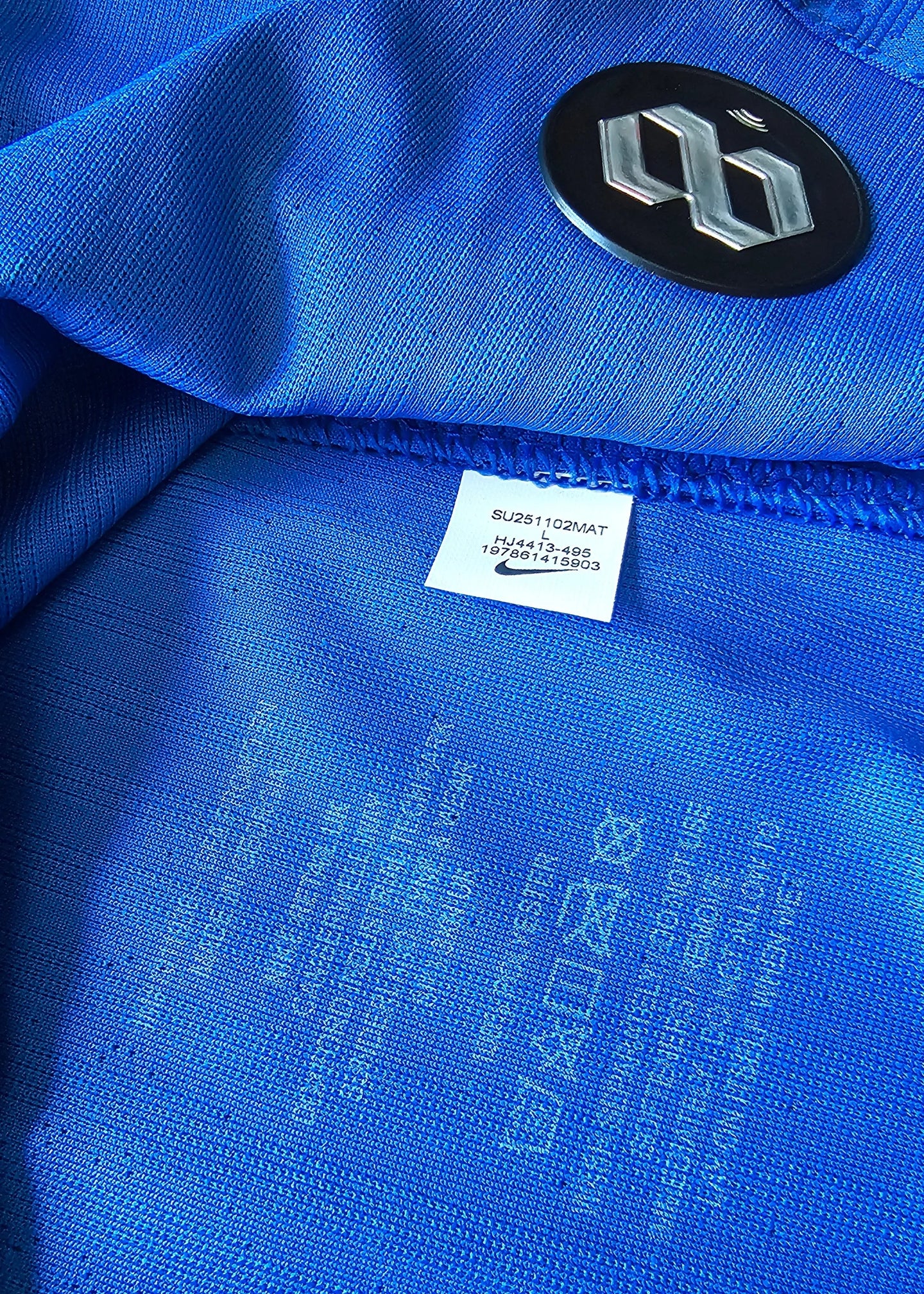 Label detail showing size L and Nike logo in blue fabric.