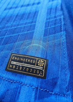 Close-up of the engineered label featuring text: ENGINEERED MB197032GL on a blue fabric background.