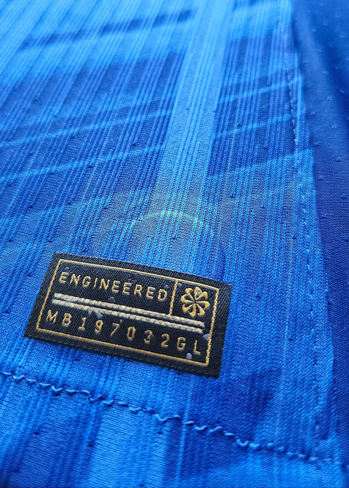 Close-up of the engineered label featuring text: ENGINEERED MB197032GL on a blue fabric background.