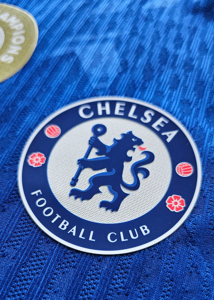Close-up of Chelsea Football Club crest featuring a blue lion and flowers.
