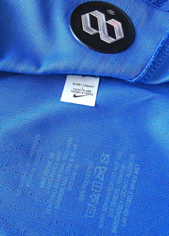 Close-up of blue football shirt showing Nike logo and size label details.