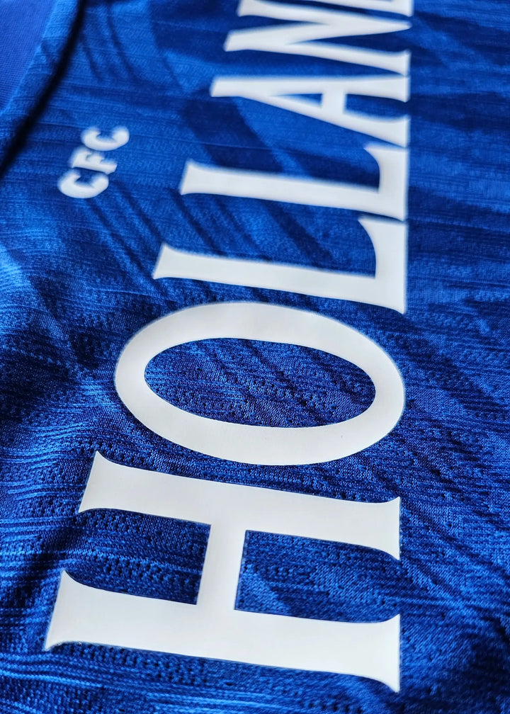 Close-up view showing the name 'HOLLAND' and 'CFC' on a blue football shirt.