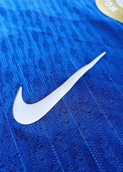 Close-up detail showing the white Nike swoosh on a blue football shirt.
