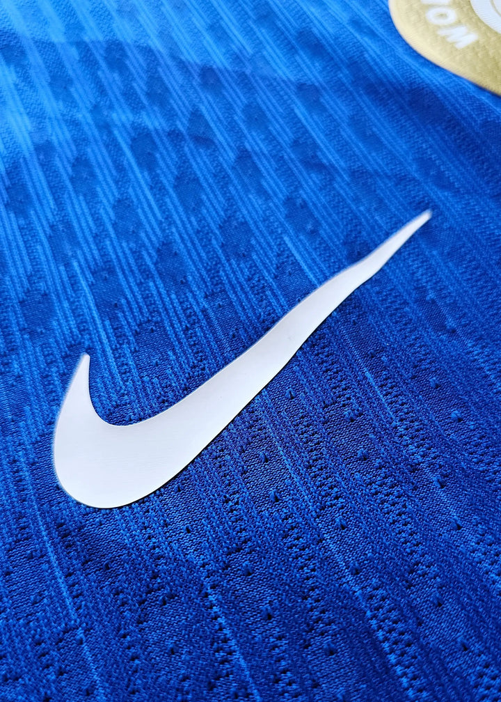Close-up detail showing the white Nike swoosh on a blue football shirt.