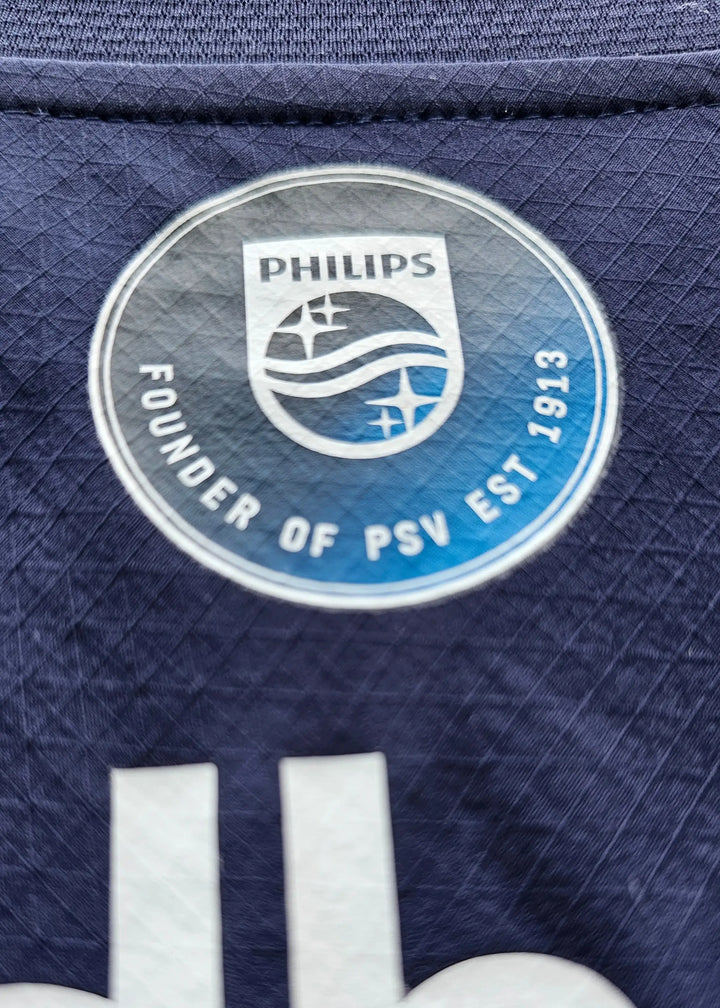 Crest detail featuring Philips and text: FOUNDER OF PSV EST 1913 on navy background.