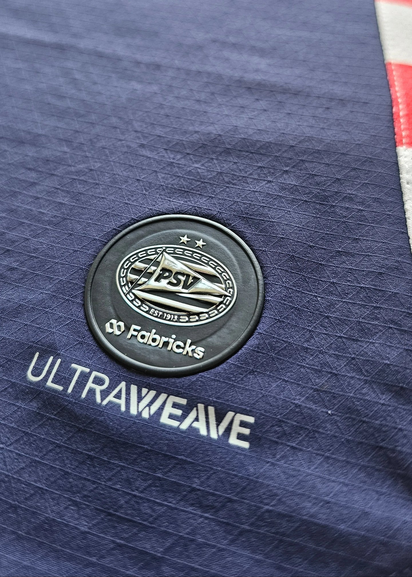 Detail view showing PSV crest with two stars, and the text 'ULTRAWEAVE' and 'Fabricks'.