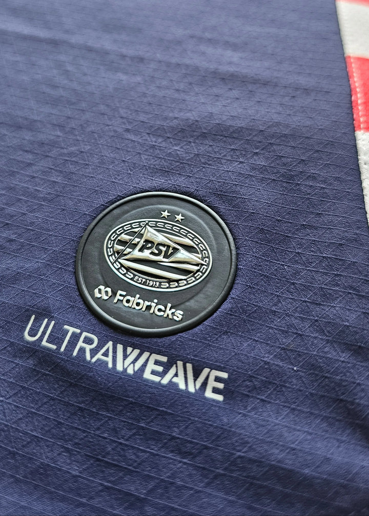 Detail view showing PSV crest with two stars, and the text 'ULTRAWEAVE' and 'Fabricks'.
