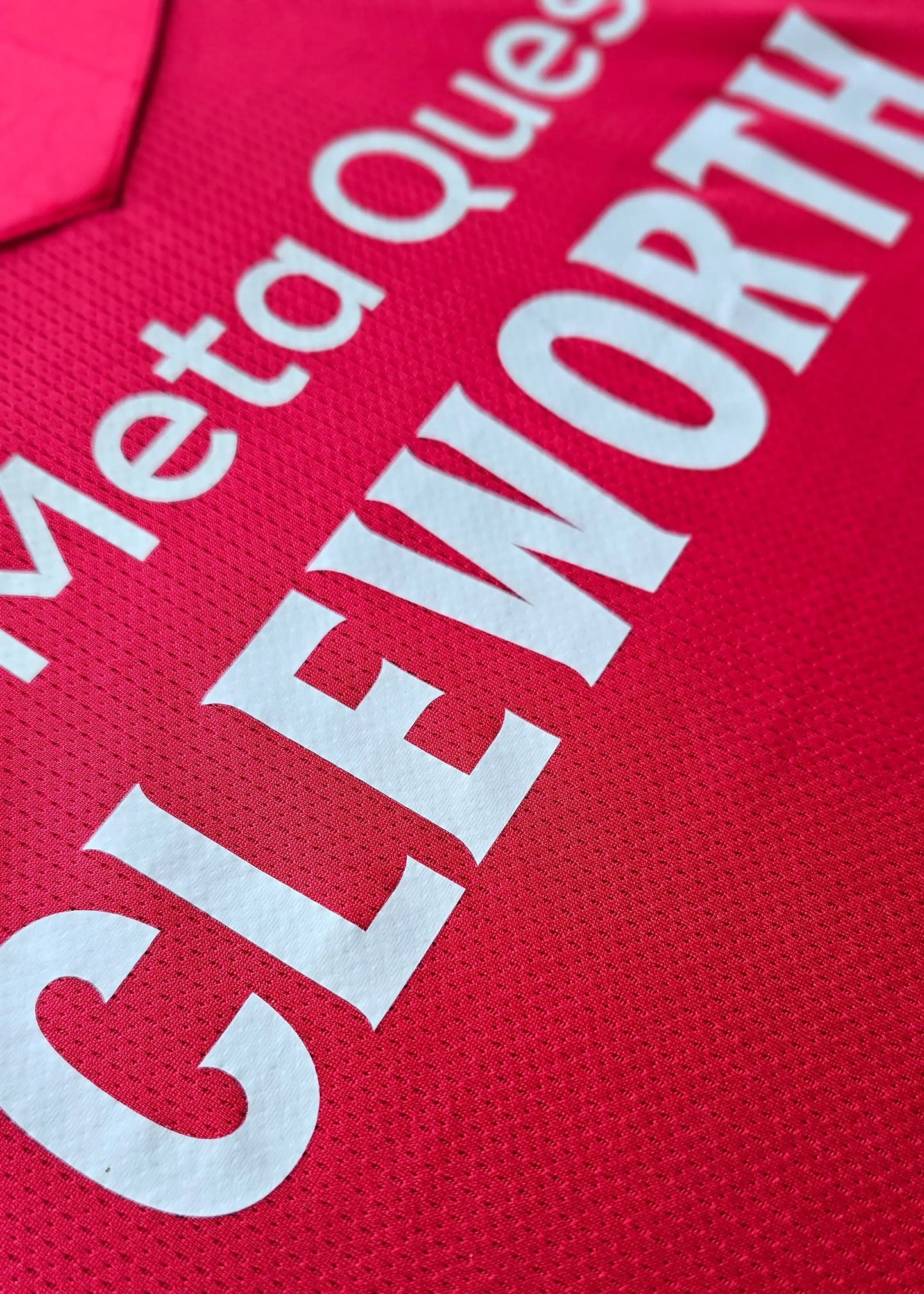 Close-up view of the pink shirt with the name 'CLEWORTH' prominently displayed.