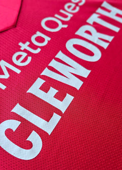 Close-up view of the pink shirt with the name 'CLEWORTH' prominently displayed.