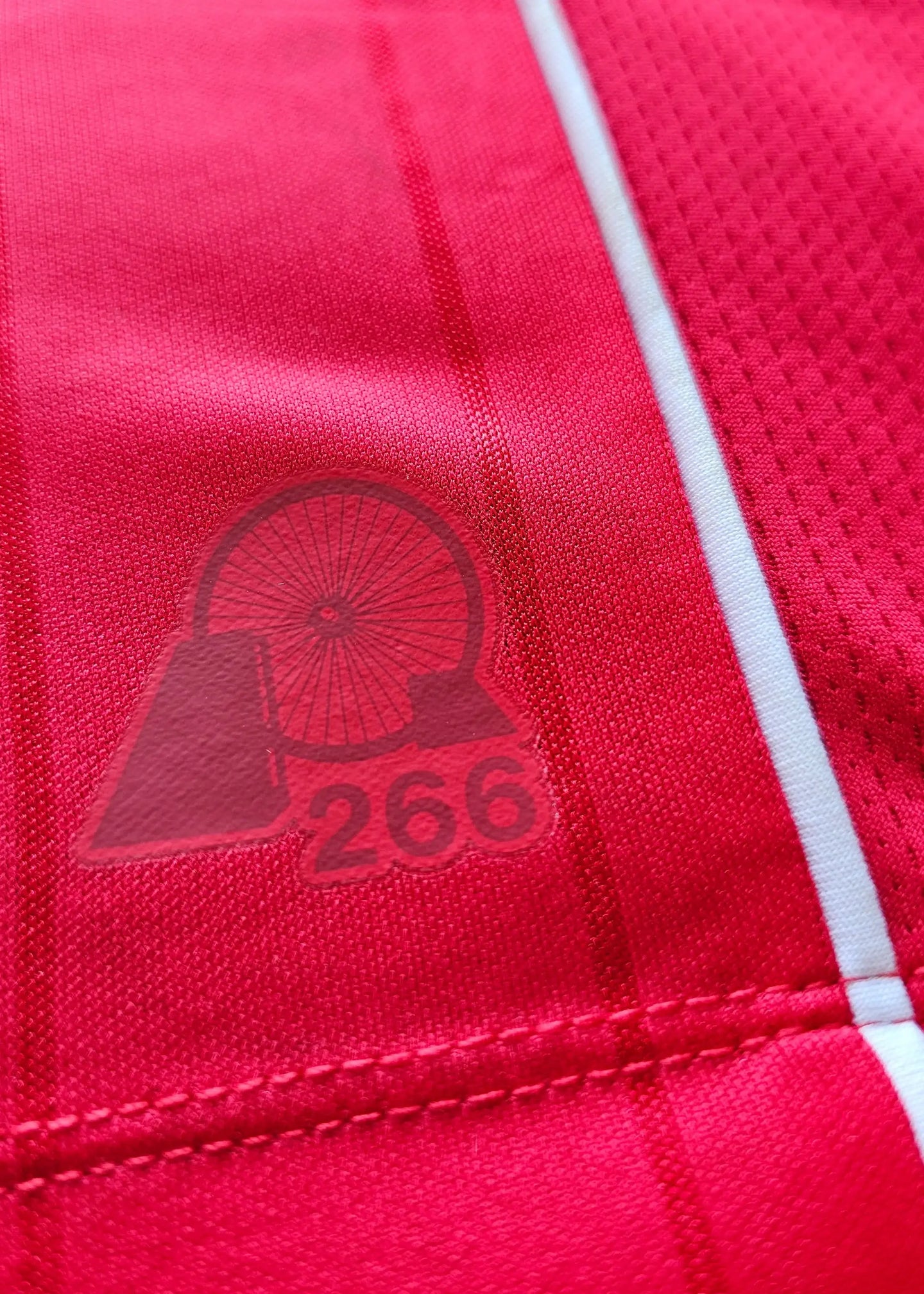 Detail view showing the red fabric with a logo featuring a wheel and the number 266.