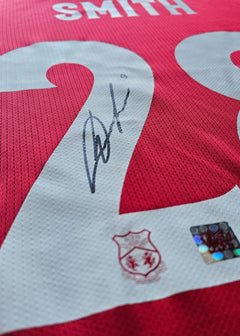 Close-up showing No. 29, player name SMITH, and signature detail on red football shirt.