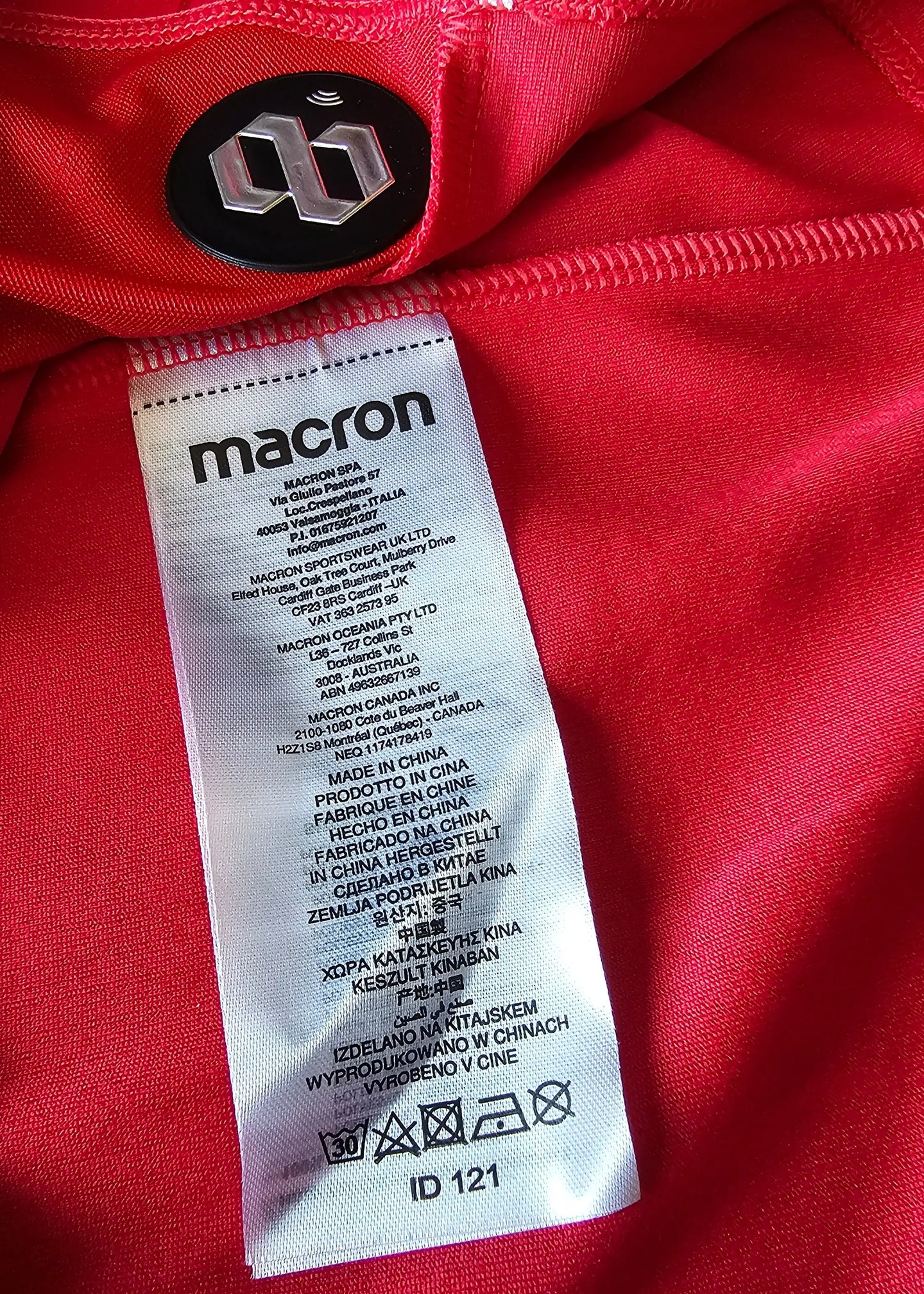 Label detail showing care instructions and manufacturer 'macron' on red fabric.
