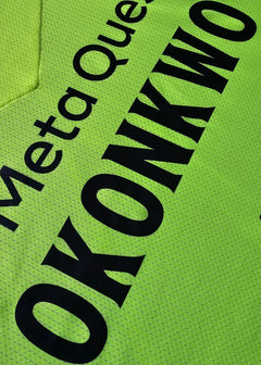 Close-up detail showing the name 'OKONKWO' in black on a bright green football shirt.