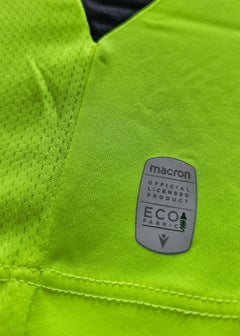 Detail view featuring the Macron label indicating Eco Fabric and licensed product status.