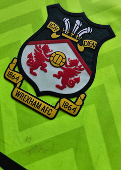 Crest detail showing Wrexham AFC emblem with two red dragons and 1864 underneath.