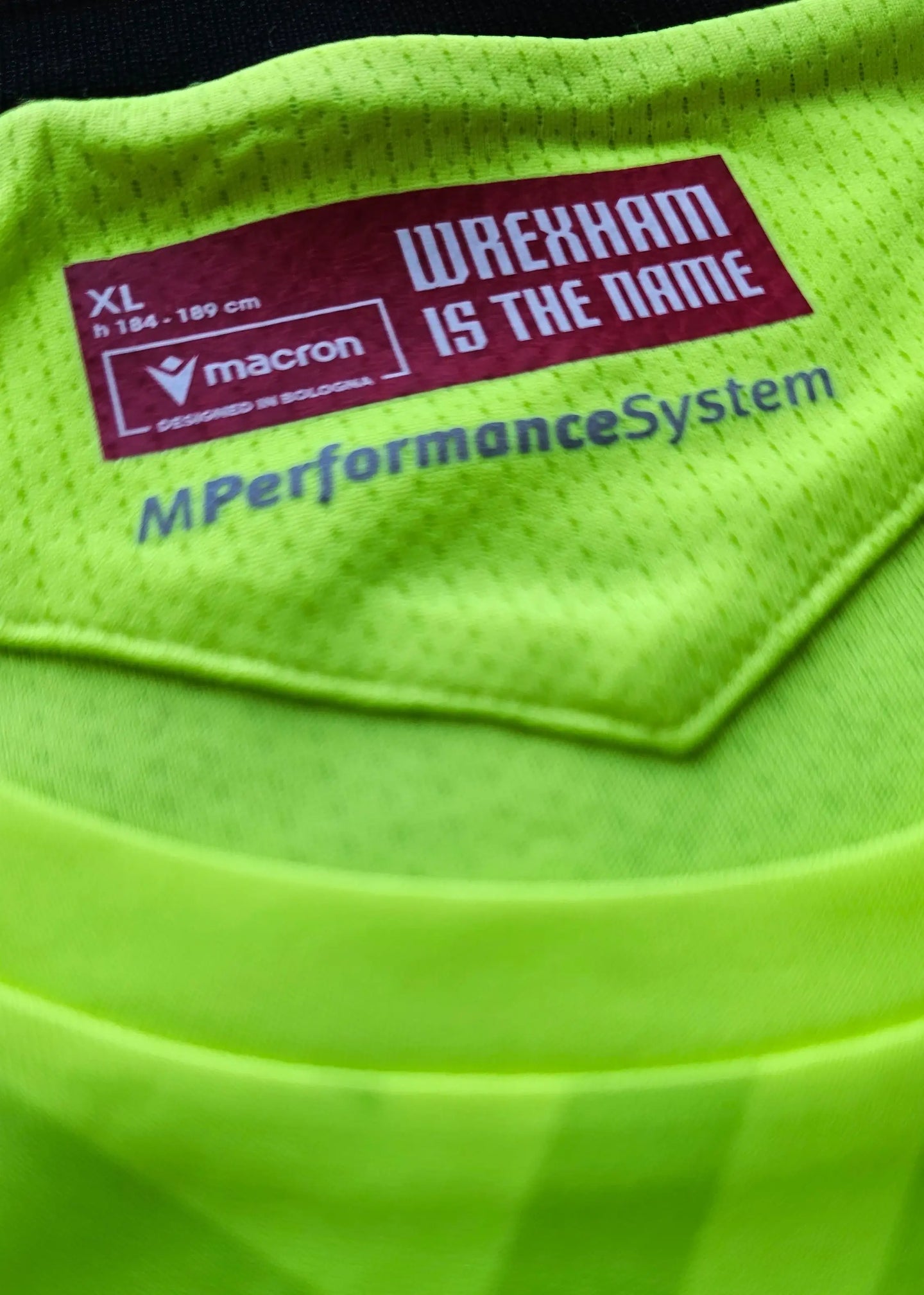 Size label showing 'WREXHAM IS THE NAME', 'XL', and 'macron' branding in bright green.
