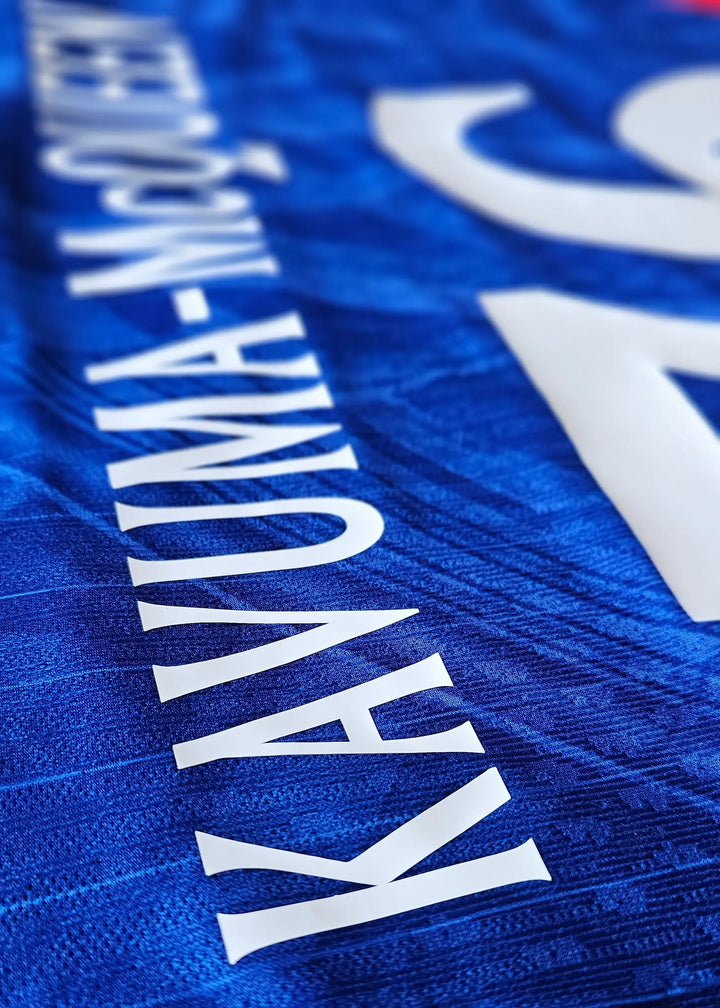 Close-up of the back showing the name KAVUMA-MCQUEEN and No. 76 on a blue football shirt.