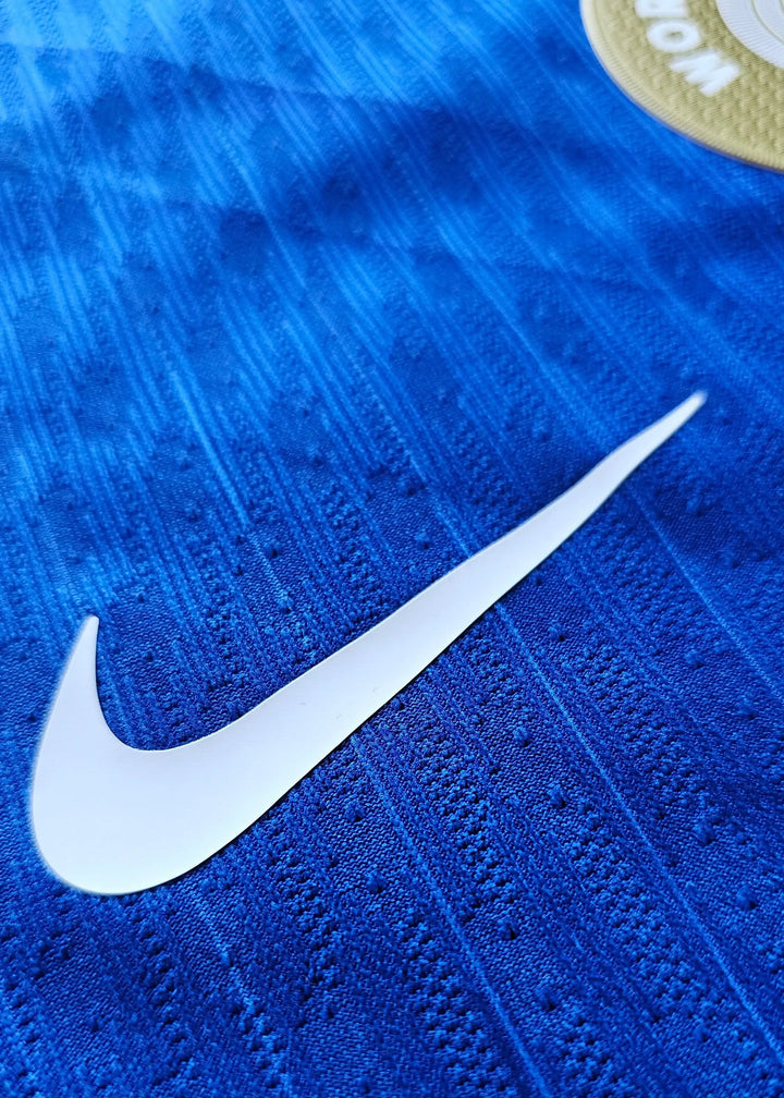 Close-up view of the Nike logo on a blue football shirt fabric.