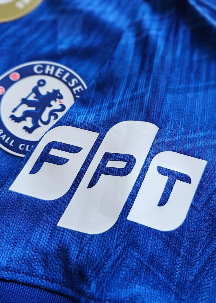 Close-up detail showing Chelsea crest and FPT sponsor on blue fabric.