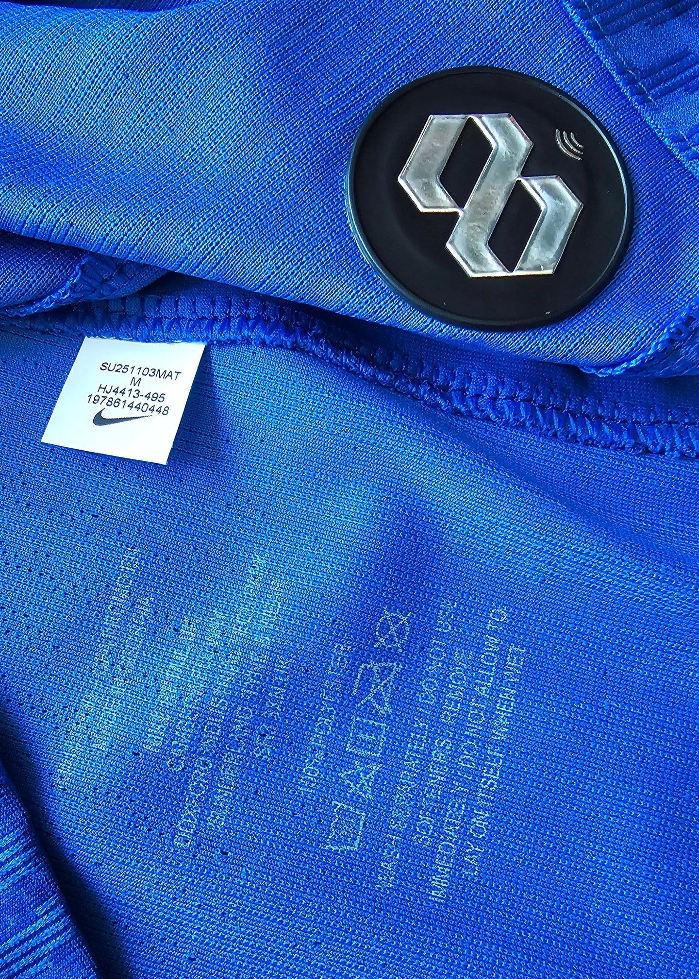 Detail view showing Nike label and care instructions on a blue football shirt.