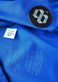 Detail view showing Nike label and care instructions on a blue football shirt.