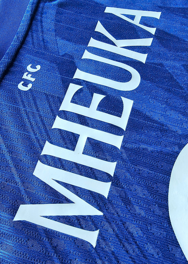 Close-up of the back showing the name MHEUKA and the CFC crest in blue fabric.