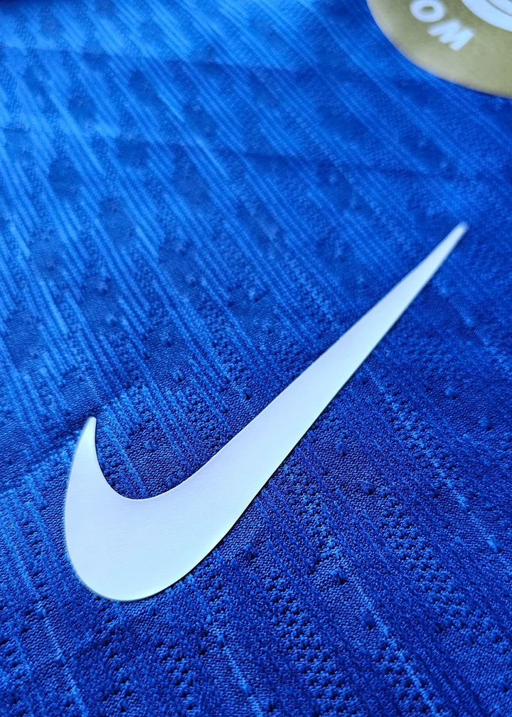 Close-up view of the Nike logo on a blue football shirt with textured fabric.