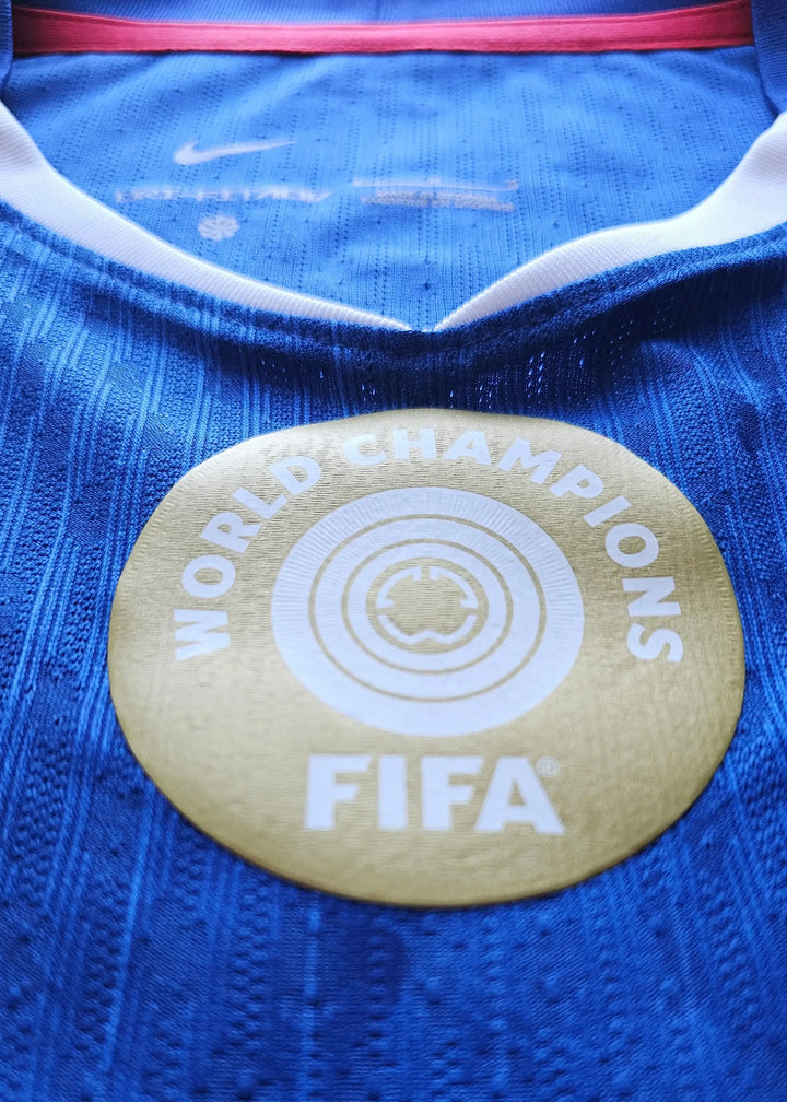 Crest detail showing FIFA World Champions badge in gold on blue fabric.
