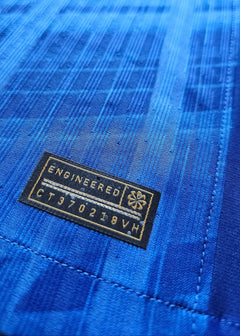 Close-up detail of a blue fabric with 'ENGINEERED' tag and code 'CT970218VH'.