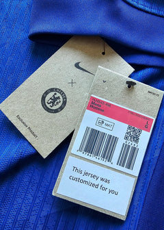 Close-up of Chelsea F.C. tags showing logo, size LG, and "This jersey was customized for you".